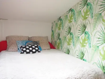 a bedroom with a bed with a floral wallpaper at Gîte Tanagra : Maison avec piscine et vue exceptionnelle in Roquefort-les-Cascades