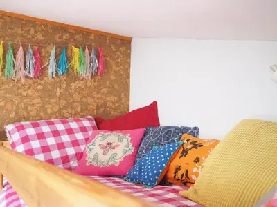 a couch with colorful pillows on it in a room at Gîte Tanagra : Maison avec piscine et vue exceptionnelle in Roquefort-les-Cascades
