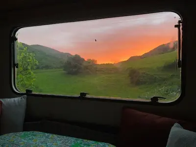 a view of a sunset from a train window at Gîte Aurinko : caravane avec bain nordique in Roquefort-les-Cascades