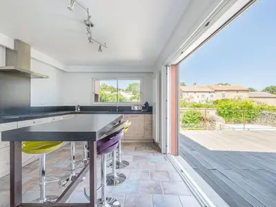 a kitchen with a black counter and yellow bar stools at Retreat in Saint Denis in Saint-Denis
