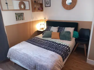a bedroom with a bed and a blue chair at Le studio des halles avec climatisation 15m2 in Narbonne
