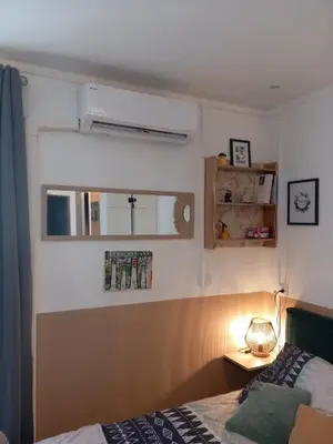 a bedroom with a bed and a table with a lamp at Le studio des halles avec climatisation 15m2 in Narbonne