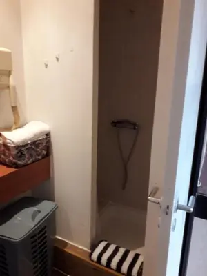 a small bathroom with a shower in the corner at Le studio des halles avec climatisation 15m2 in Narbonne