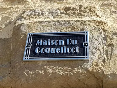 a living room with a couch and a table at Maison du Coquelicot in Tourouzelle