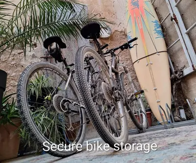 two bikes parked against a wall next to a surfboard at Maison du Coquelicot in Tourouzelle