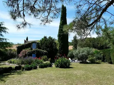 a garden in front of a house with trees and flowers at Villa L'ESTRADE in Montréal