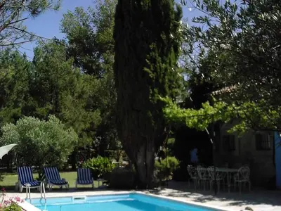 a swimming pool with two chairs and a tree at Villa L'ESTRADE in Montréal
