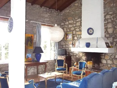 a living room with blue chairs and a stone wall at Villa L'ESTRADE in Montréal