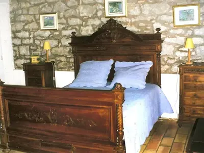 a bedroom with a large wooden bed with white pillows at Villa L'ESTRADE in Montréal