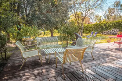 a group of chairs and a table on a wooden deck at Chambre d’Hôtes Neptune Wood in Arzens