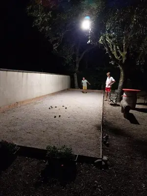 two children are playing in a courtyard at night at Chambre d’Hôtes Neptune Wood in Arzens