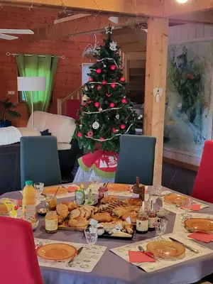 a table with a christmas tree in a room at Chambre d’Hôtes Neptune Wood in Arzens
