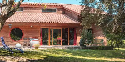 a wooden house with a table in front of it at Chambre d’Hôtes Neptune Wood in Arzens