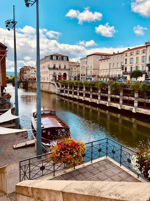 a boat is docked on a river in a city at les gîtes d'en Julio in Puylaurens