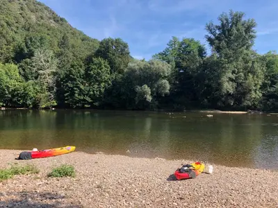 a boat on the shore of a river at les gîtes d'en Julio in Puylaurens