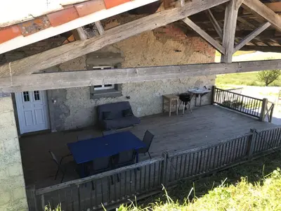 a wooden deck with a blue table and chairs on it at les gîtes d'en Julio in Puylaurens