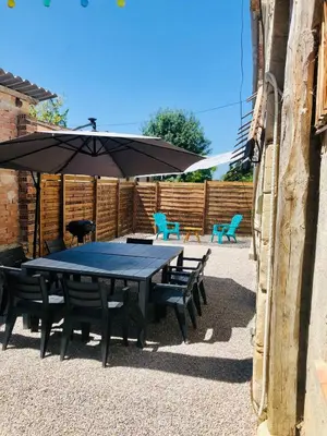 a picnic table with benches and an umbrella at les gîtes d'en Julio in Puylaurens