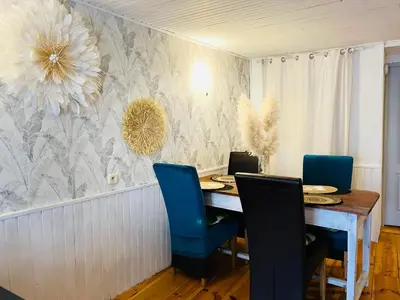 a dining room with a table and blue chairs at Le gîte de la vallée du Douctouyre in Dun