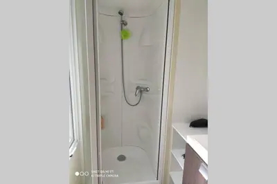 a bathroom with a shower with a glass door at Mobilhome climatisé et ombragé in Port-la-Nouvelle
