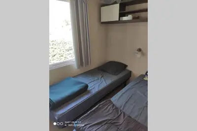 a small room with a bed and a window at Mobilhome climatisé et ombragé in Port-la-Nouvelle