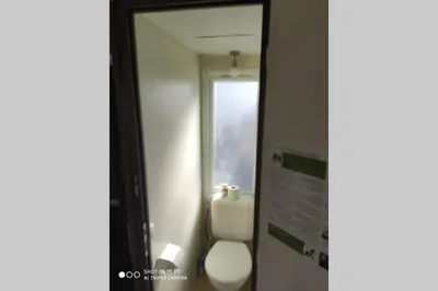 a bathroom with a white toilet and a mirror at Mobilhome climatisé et ombragé in Port-la-Nouvelle