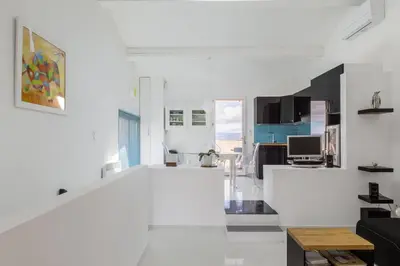 a white living room with a couch and a table at Opuntia (Pech) location en Méditerranée in Escales
