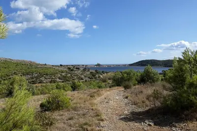 a dirt road with a view of a body of water at Opuntia (Pech) location en Méditerranée in Escales