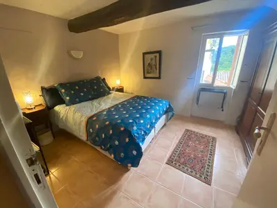 a bedroom with a bed and a window at La Maisonnette D'Agel in Agel