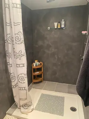 a shower with a shower curtain in a bathroom at La Maisonnette D'Agel in Agel