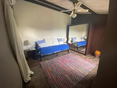 a bedroom with a blue bed and a mirror at La Maisonnette D'Agel in Agel