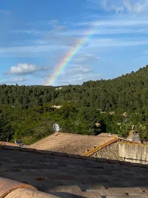 a rainbow in the sky over a roof at La Maisonnette D'Agel in Agel