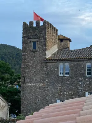 a castle with a flag on top of it at La Maisonnette D'Agel in Agel