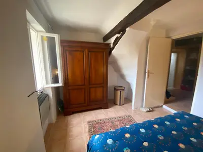 a bedroom with a bed and a wooden cabinet at La Maisonnette D'Agel in Agel