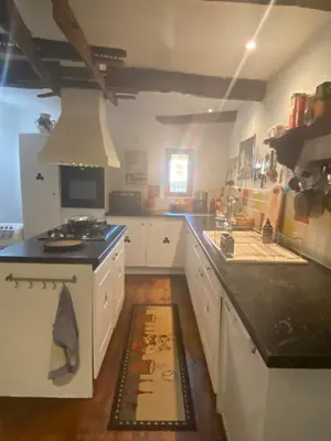 a kitchen with white cabinets and a black counter top at La Maisonnette D'Agel in Agel