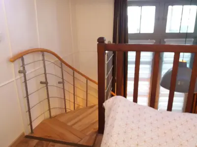 a room with a staircase with a bed and a window at Studio la Nuit au Coeur de ville in Limoux