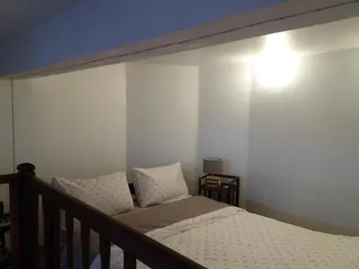 a bedroom with a bed and a light on the wall at Studio la Nuit au Coeur de ville in Limoux