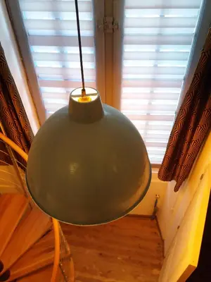 a large green light hanging in front of a window at Studio la Nuit au Coeur de ville in Limoux