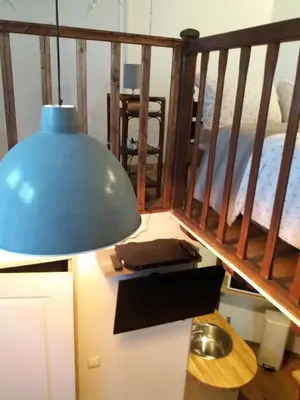 a blue lamp sitting on a table next to a staircase at Studio la Nuit au Coeur de ville in Limoux