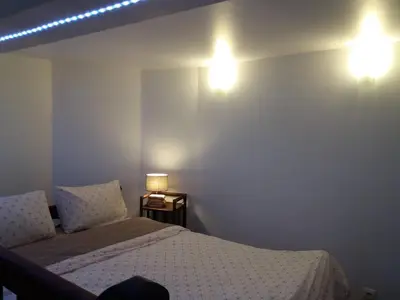 a bedroom with a bed and two lights on the wall at Studio la Nuit au Coeur de ville in Limoux