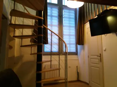a spiral staircase in a room with a window at Studio la Nuit au Coeur de ville in Limoux