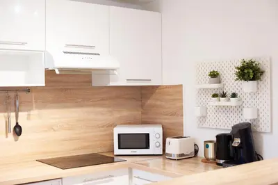 a kitchen with white cabinets and a microwave at 101 Cour de la Bastide in Carcassonne