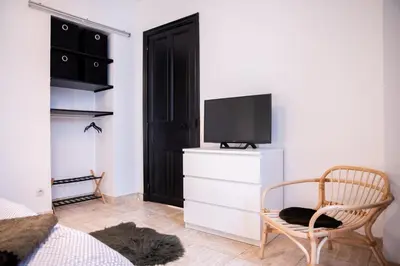 a bedroom with a bed and a tv and a chair at 101 Cour de la Bastide in Carcassonne