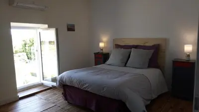 a bedroom with a bed with two night stands and two lamps at La Vigneronne in Villelongue-dʼAude