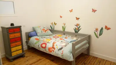 a childs bedroom with a bed and a night stand at La Vigneronne in Villelongue-dʼAude