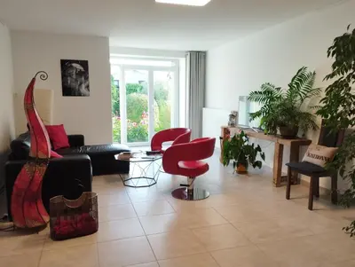 a living room with a couch and a red chair at La Vigneronne in Villelongue-dʼAude