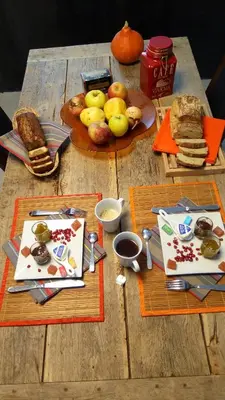 a wooden table topped with plates of food and bread at La Vigneronne in Villelongue-dʼAude