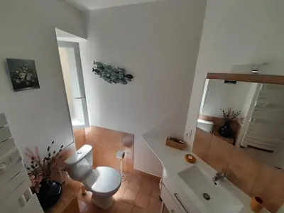 a bathroom with a toilet and a sink and a mirror at Villa Saint Léon in Badens