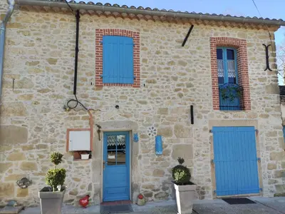a stone house with blue doors and windows at Le clos de josephine in Peyregoux