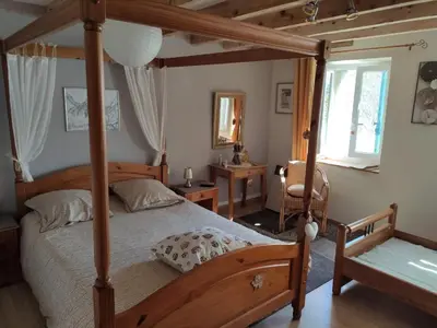 a bedroom with a canopy bed and a desk at Le clos de josephine in Peyregoux