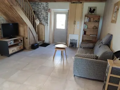 a living room with a couch and a tv at Le clos de josephine in Peyregoux